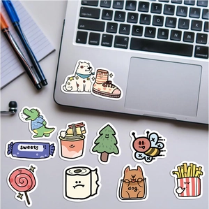 Detailansicht niedlicher wasserfester Cartoon-Aufkleber mit Dinos auf einem Laptop