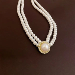 Vue macro détaillée du collier de perles baroques double épaisseur avec pendentif doré