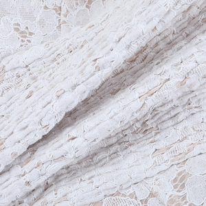 Detailed macro view of white floral lace fabric and elastic pleated embroidery texture