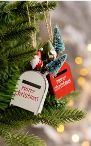 Close-up of decorative Christmas mailbox ornaments hanging on a festive tree branch