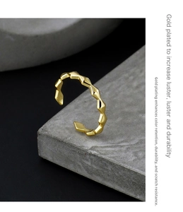 Detailed view of gold plated geometric faceted ring on industrial grey surface