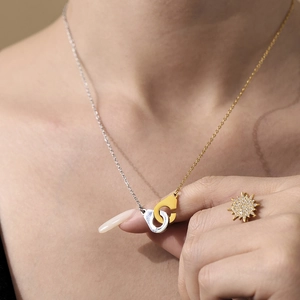 Collier menottes bicolore et bague étoile scintillante portés par un mannequin femme