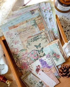 Macro detail of vintage stationery papers and stickers set on a rustic wooden tray