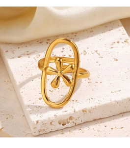 Detail of a gold floral oval ring on a textured stone base with soft warm lighting