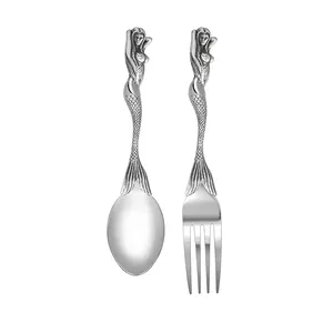 Detailed view of vintage mermaid handle carving on stainless steel spoon and fork set