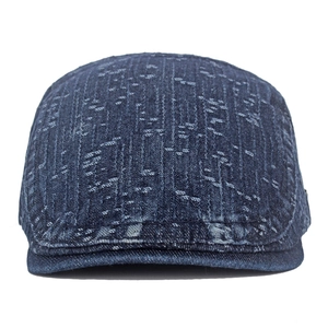 Detail of dark blue newsboy cap in snow-washed denim fabric with vintage marble texture