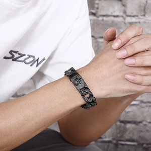 Close-up of punk style titanium steel cuban link bracelet with detailed skulls on wrist