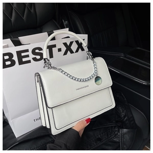 White leather shoulder bag with silver handle and fashion chain detail in car interior