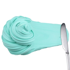 Texture detail of mint green slime being spread smoothly with a metal spatula tool
