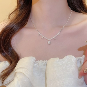 Detail of silver flower pendant necklace with white pearls on elegant model neck