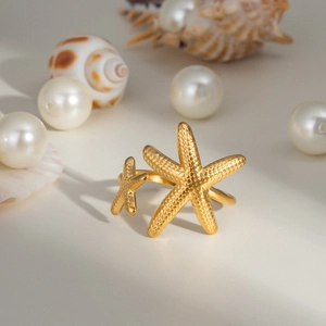 Détail de la bague étoile de mer dorée avec perles et coquillages style océan