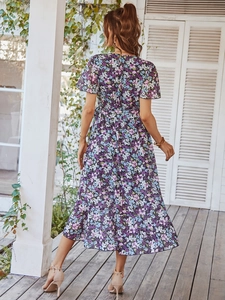 Détail de la robe fleurie montrant des manches courtes volantées et un dos drapé élégant