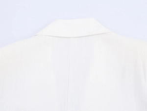 Detailed close-up of white linen blend collar and back stitching on casual oversized coat