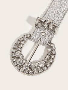 Close-up of sparkling silver rhinestone buckle and glitter belt with detailed crystal inlay