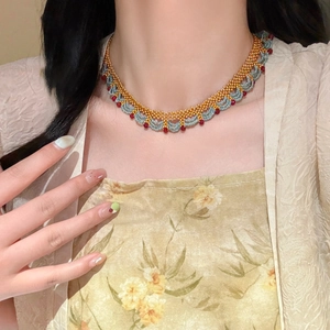 Vue détaillée du collier ras-de-cou fait main avec perles dorées et bleues sur un mannequin