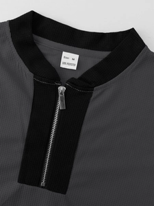 Detailed macro view of dark grey waffle fabric texture and zip collar of men's tracksuit