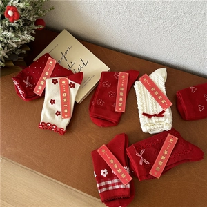 Detail of red festive cotton crew socks with auspicious tags on warm wood background