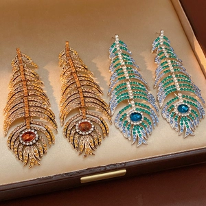 Detailed macro of vintage leaf feather earrings with colorful rhinestones in a box