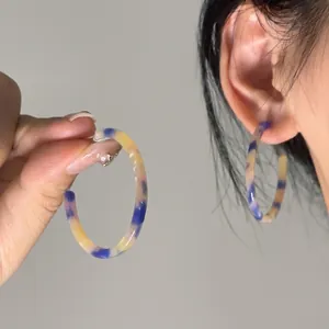 Bohemian style round resin hoop earrings with blue and yellow marble pattern and fringe shell