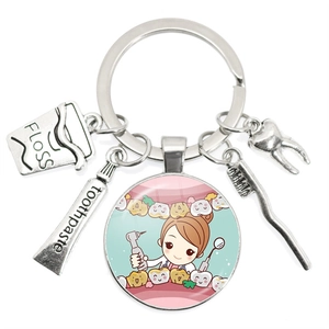 Silver dental keychain featuring toothbrush toothpaste and cartoon dentist glass pendant