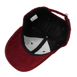 Close-up of wine red corduroy baseball cap interior with 100% cotton washing label