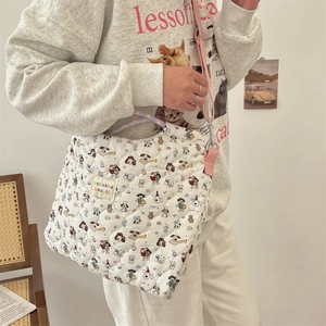 Détail d'un sac cabas en toile matelassée avec motifs de dessins animés colorés