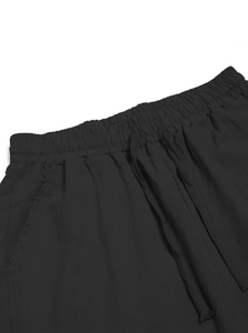Close-up of black cotton linen trousers featuring elastic drawstring waist and side pockets