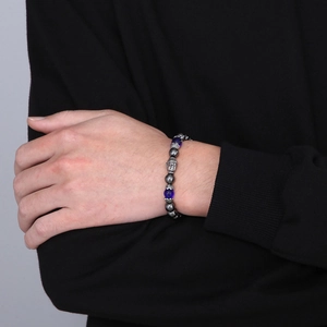 Macro detail of blue beads and silver Buddha head on men's beaded elastic bracelet