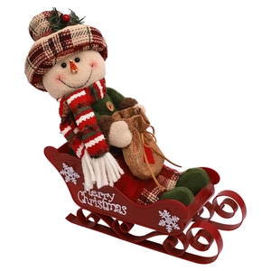 Christmas snowman plush doll sitting in a red metal sleigh with Merry Christmas text
