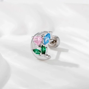 Silver crescent moon earring with colorful heart zircon on white silk background