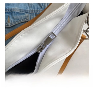 Detail shot of smooth silver zipper on a premium white leather large tote bag