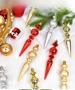 Close-up of red, gold, and silver festive finial ornaments on white faux fur background