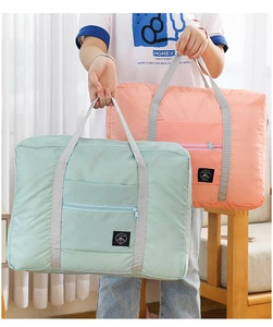 Detail showing foldable travel bag with trolley sleeve and front zipper pocket