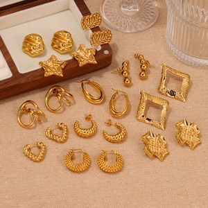 Flat lay of multiple golden geometric earrings including heart and star shapes