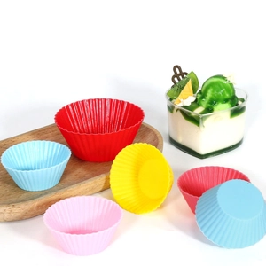 Colorful silicone muffin cups and round cupcake molds displayed on a wooden tray