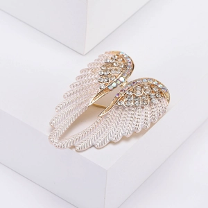 Detailed close-up of sparkling angel wing brooch with crystals and gold finish