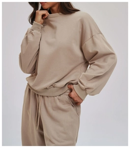 Detail view of beige oversized crewneck sweatshirt with ribbed cuffs and side pocket