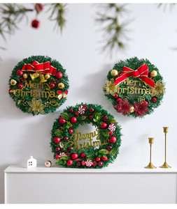 Close-up of three festive Christmas wreaths with red berries and golden Merry Christmas signs