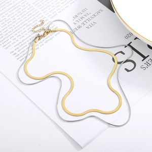 Double layered gold and silver herringbone snake chain necklace on aesthetic book background