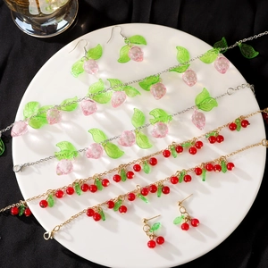 Sweet strawberry and cherry resin pendant necklaces and earrings on a white jewelry plate