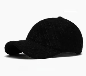 Detail of black lambswool baseball cap featuring chunky cable knit texture and warm brim