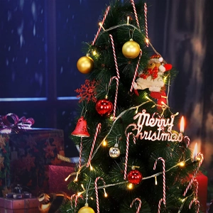 Close-up of assorted Christmas tree ornaments including candy canes and bells in warm lighting