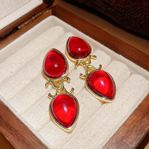 Close-up of vintage red waterdrop earrings with gold setting in a jewelry box