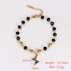 Detail of gold chain bracelet with lightning bolt charm and black faceted beads