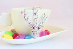 Close-up of sparkling crystal encrusted reindeer head keychain in a decorative cup