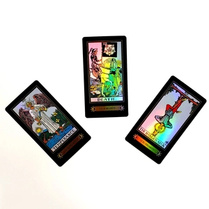 Macro detail of holographic gold tarot cards featuring Temperance and Death with black borders
