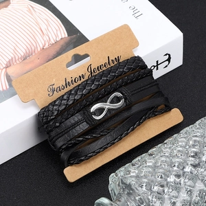 Détail de quatre bracelets en cuir tressé pour hommes avec symbole de l'infini sur une carte