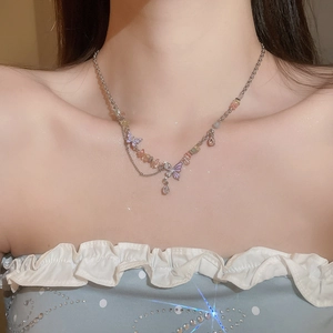 Detail of colorful beads and purple butterfly charms on a silver chain necklace