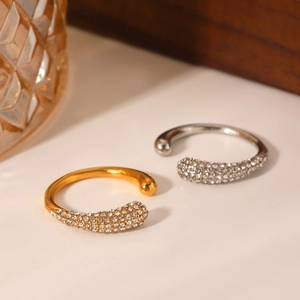 Detail showing gold and silver pavé crystal ear cuffs on a textured surface