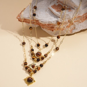 Retro multi-layer tiger eye stone flower pendant necklace displayed on a natural rock